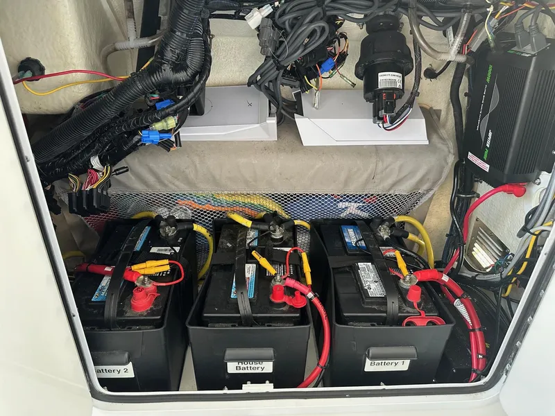Slide: The Image of 2019 Regulator 28 boat battery compartment with wiring and three labeled batteries. - 13