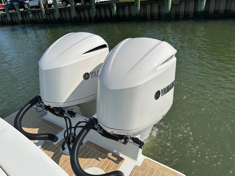 Slide: The Image of Twin Yamaha outboard engines on a 2019 Regulator 28 boat, docked in calm waters. - 15
