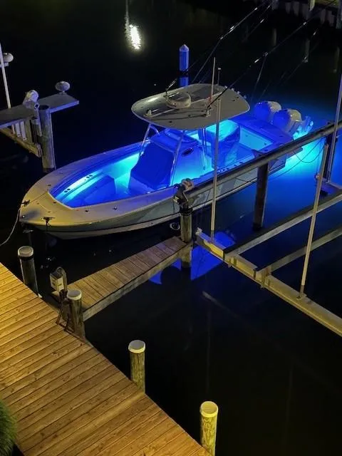 Slide: The Image of 2019 Regulator 28 boat with blue underwater lights docked at night. - 19