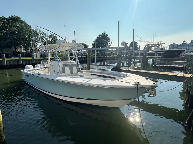 Slide: The Image of 2019 Regulator 28 boat docked in a marina under clear skies. - 2