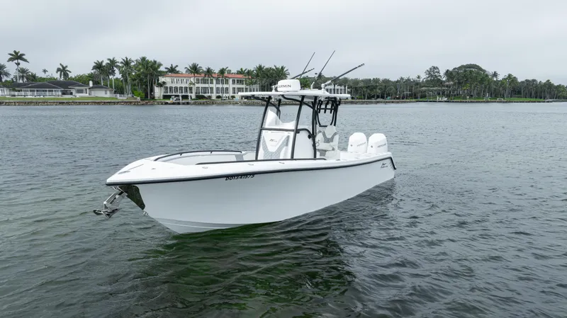 Slide: The Image of 2024 Streamline 26 CC boat on calm water near luxury waterfront homes. - 2