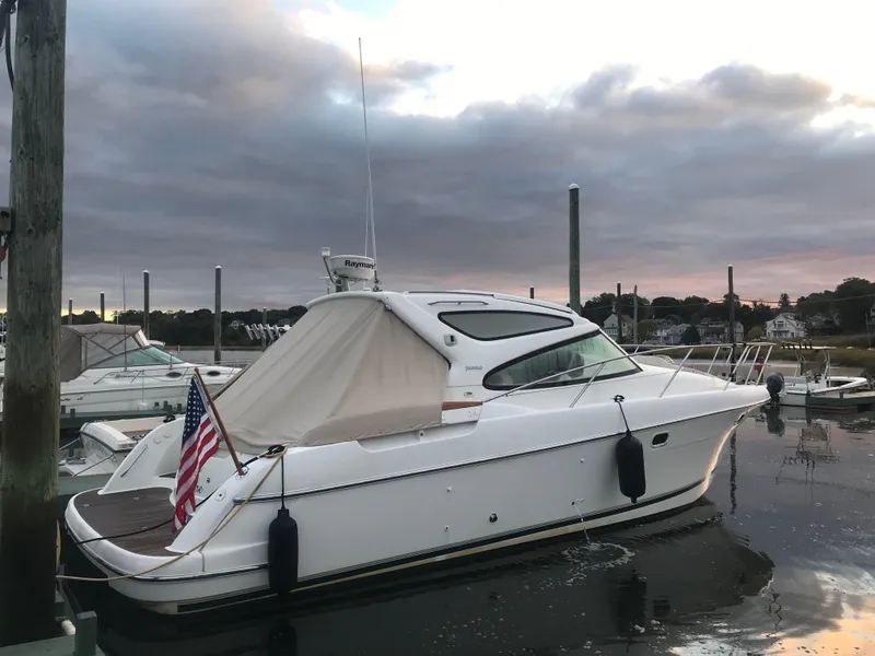 Slide: The Image of 2008 Jeanneau Prestige 34 Hardtop yacht docked at sunset with American flag. - 1