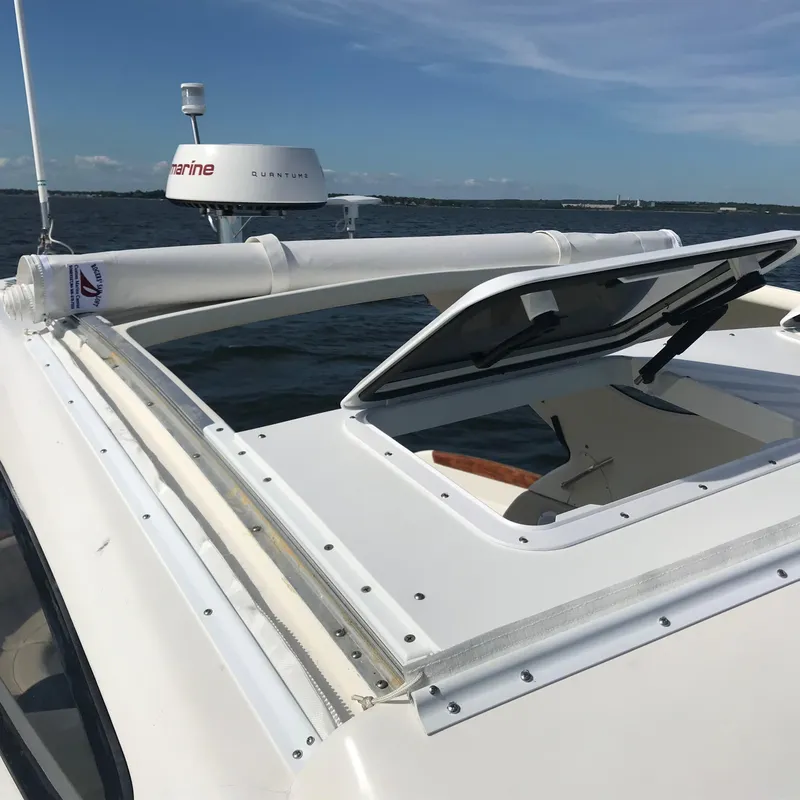 Slide: The Image of 2008 Jeanneau Prestige 34 Hardtop boat with open sunroof on the water. - 15