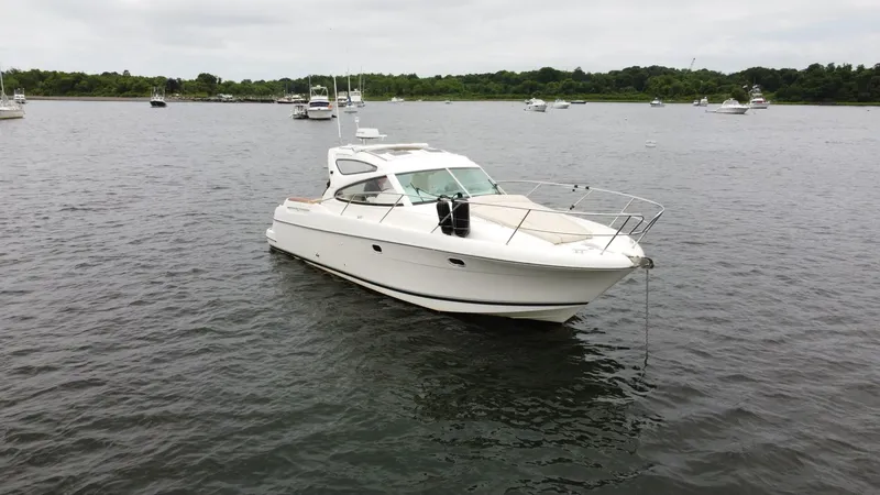 Slide: The Image of 2008 Jeanneau Prestige 34 Hardtop yacht anchored on calm water. - 2
