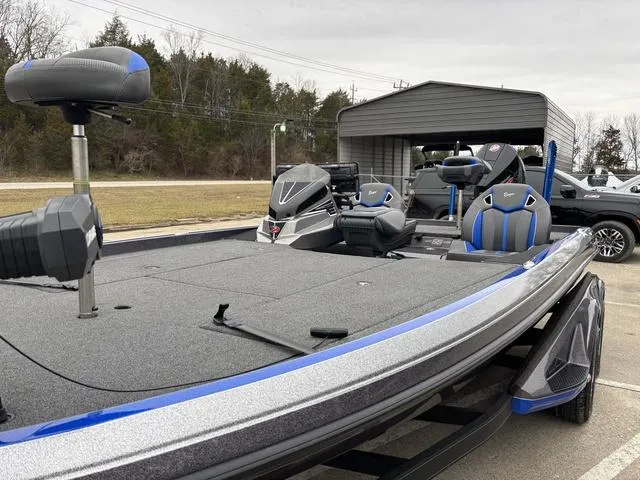 Slide: The Image of 2023 Ranger Z521R bass boat with blue accents, parked outdoors. - 13