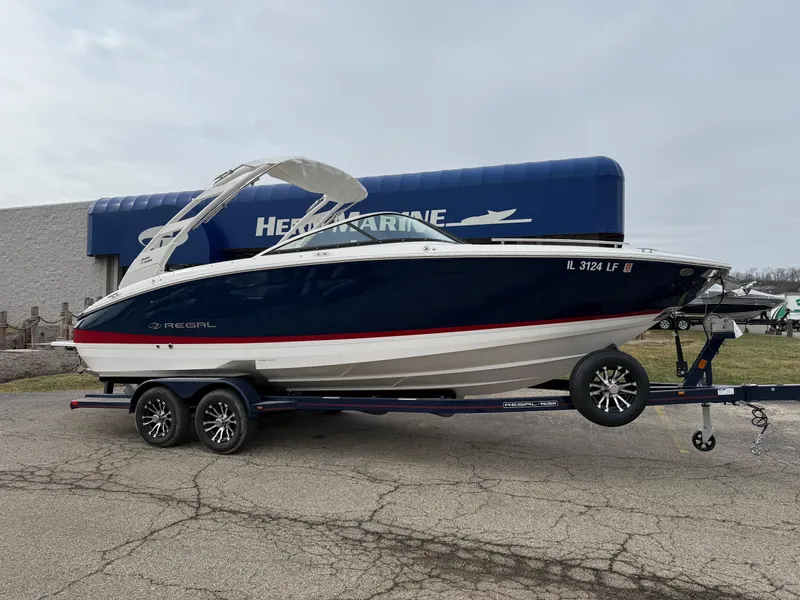Slide: The Image of 2023 Regal LS6 boat on trailer, parked outside marine dealership. - 0