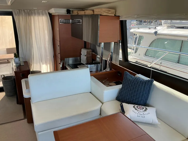 Slide: The Image of Interior of a 2015 Prestige 500 yacht with modern seating and kitchen area. - 11
