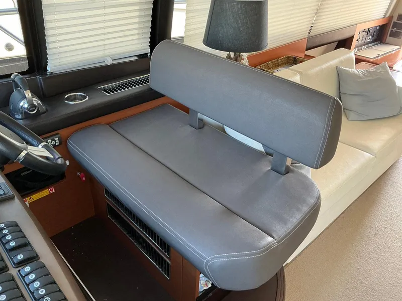 Slide: The Image of Captain's seat in 2015 Prestige 500 yacht interior, featuring gray upholstery and modern design. - 14