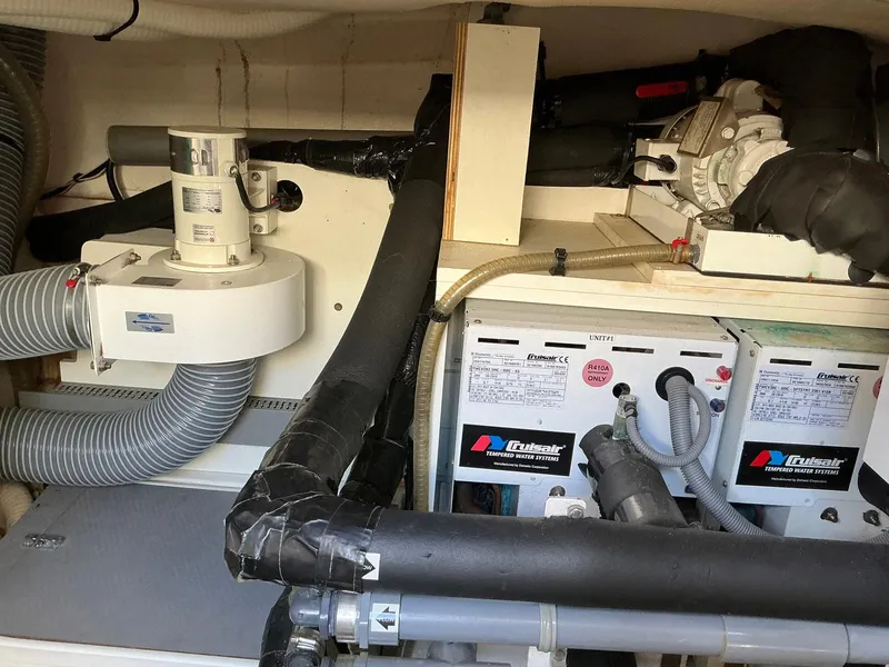 Slide: The Image of Engine room of a 2015 Prestige 500 yacht, featuring mechanical components and piping. - 23