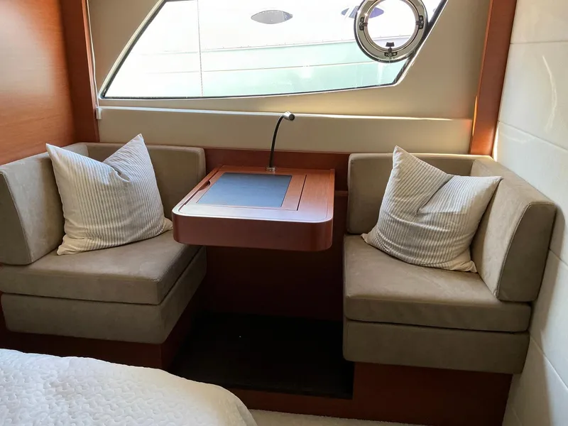 Slide: The Image of Cozy seating area in a 2015 Prestige 500 yacht with cushions and a small table. - 29