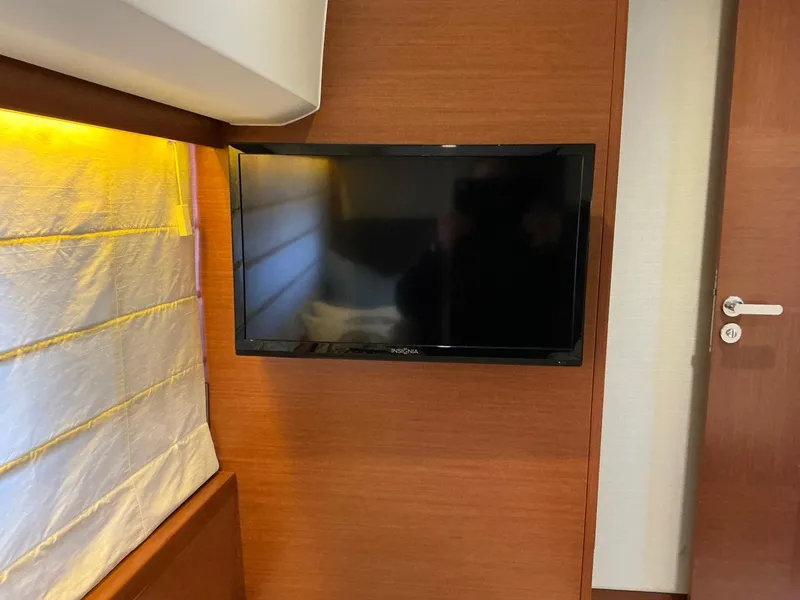 Slide: The Image of Wall-mounted TV in a 2015 Prestige 500 yacht interior with wood paneling. - 43