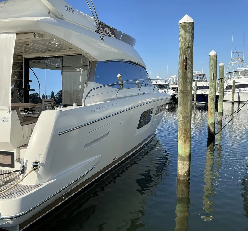 Slide: The Image of Luxury 2015 Prestige 500 yacht docked at marina under clear blue sky. - 6