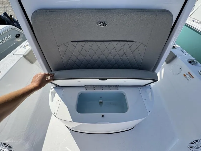 Slide: The Image of 2025 Sportsman Masters 227 boat with open storage compartment and cushioned lid. - 11