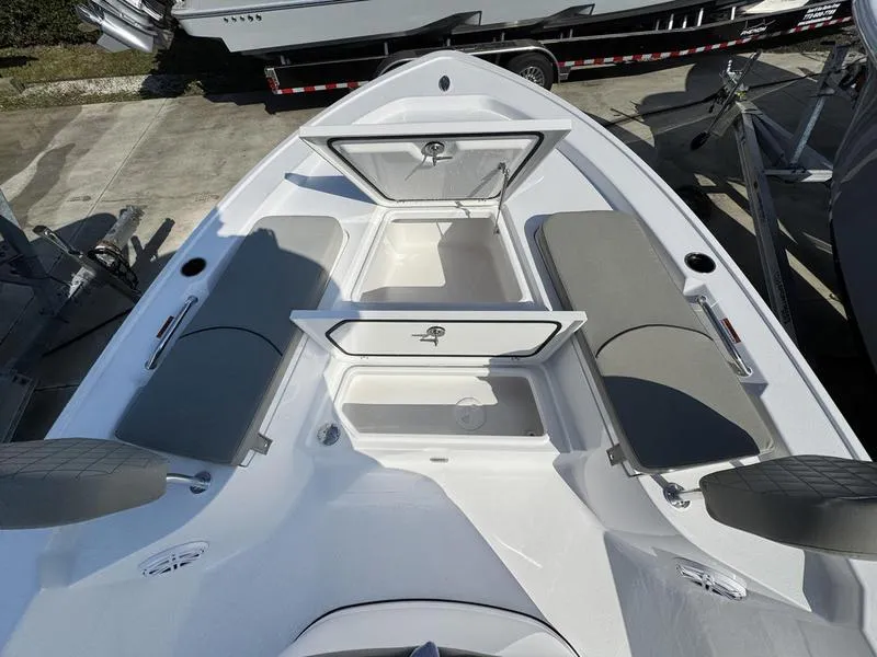 Slide: The Image of 2025 Sportsman Masters 227 boat interior with open storage compartments and gray seating. - 12