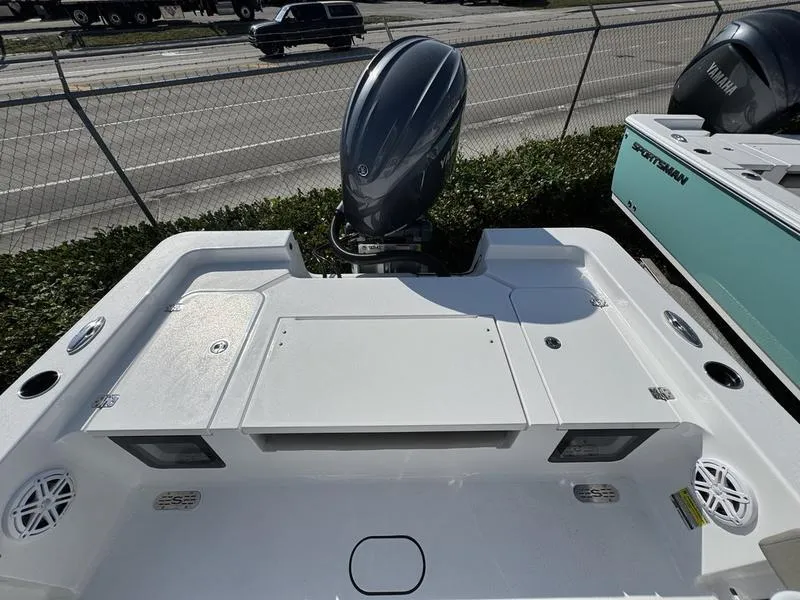 Slide: The Image of 2025 Sportsman Masters 227 boat with outboard motor, docked near a road. - 16