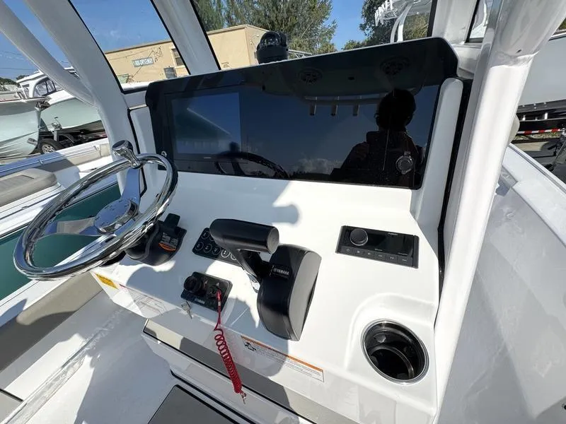 Slide: The Image of Control panel of 2025 Sportsman Masters 227 boat with steering wheel and throttle. - 19