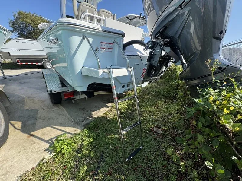 Slide: The Image of 2025 Sportsman Masters 227 boat with ladder and outboard motor in a marina setting. - 27