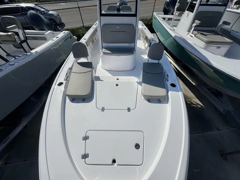 Slide: The Image of 2025 Sportsman Masters 227 boat with seating and storage, displayed in a showroom. - 8