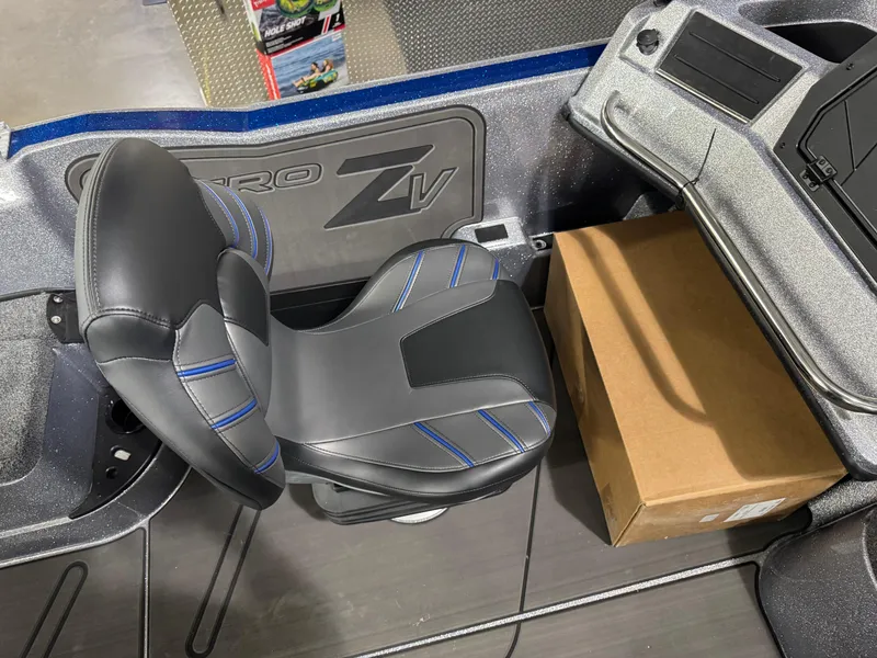Slide: The Image of 2025 Nitro ZV21 boat interior with black and blue seat and cardboard box. - 18