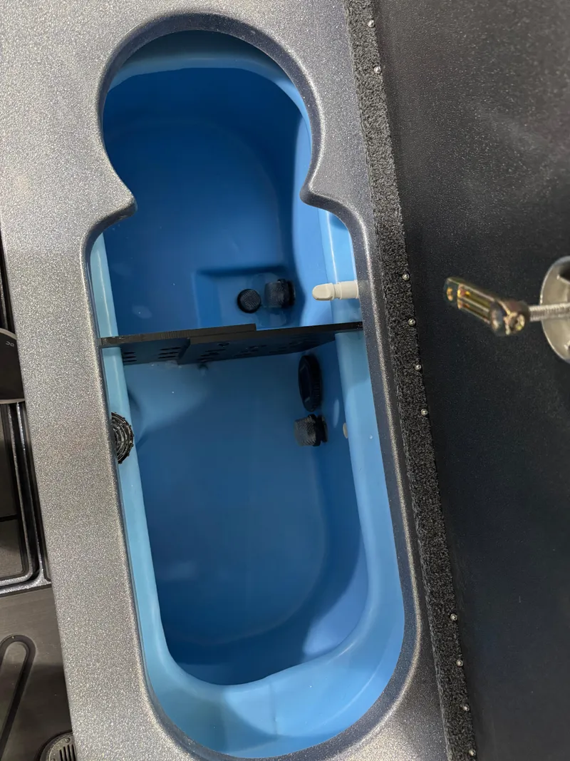 Slide: The Image of 2025 Nitro ZV21 boat compartment with blue interior and key lock mechanism. - 24