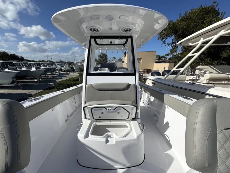 Slide: The Image of 2025 Sportsman Heritage 261 boat interior with seating and storage, under a clear blue sky. - 10