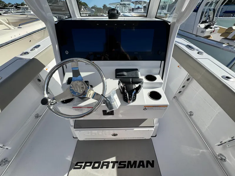 Slide: The Image of 2025 Sportsman Heritage 261 boat cockpit with dual screens and steering wheel. - 16