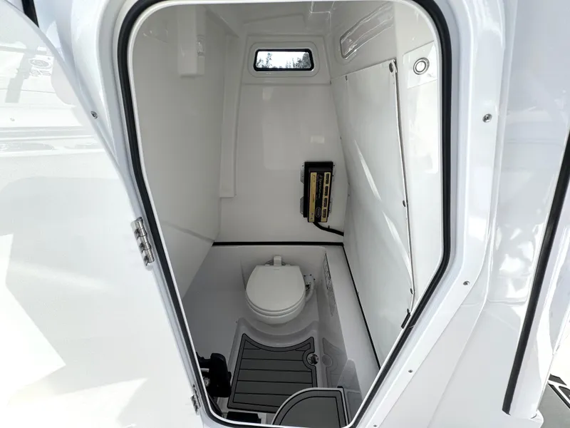 Slide: The Image of 2025 Sportsman Heritage 261 boat interior with compact marine toilet and window. - 22
