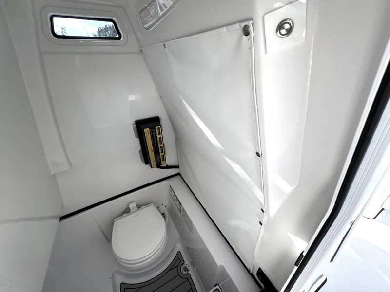 Slide: The Image of 2025 Sportsman Heritage 261 boat interior with compact marine toilet and storage. - 24
