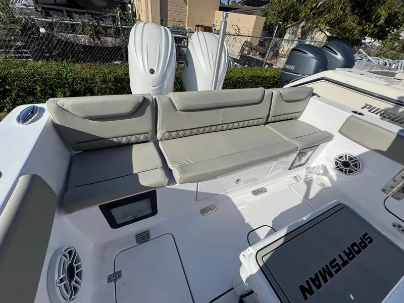 Slide: The Image of 2025 Sportsman Heritage 261 boat interior with cushioned seating and dual outboard motors. - 26