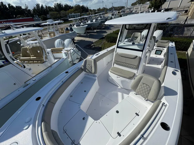 Slide: The Image of 2025 Sportsman Heritage 261 boat with spacious seating and modern design in a marina setting. - 6