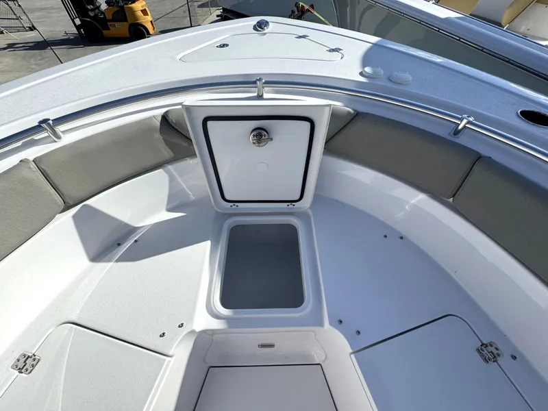 Slide: The Image of 2025 Sportsman Heritage 261 boat interior with open storage compartment and cushioned seating. - 7
