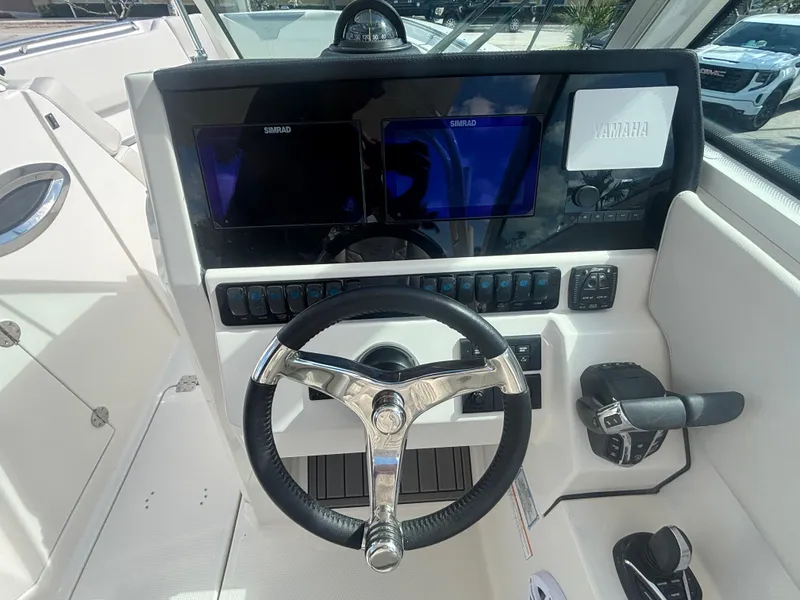 Slide: The Image of 2025 Sailfish 276 DC boat dashboard with steering wheel and navigation screens. - 14