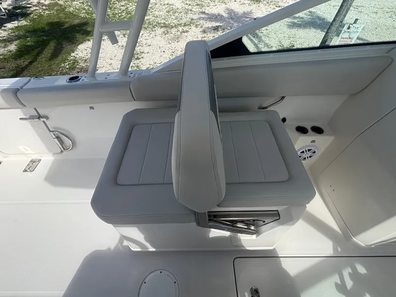 Slide: The Image of 2025 Sailfish 276 DC boat interior with cushioned seating and storage compartment. - 16