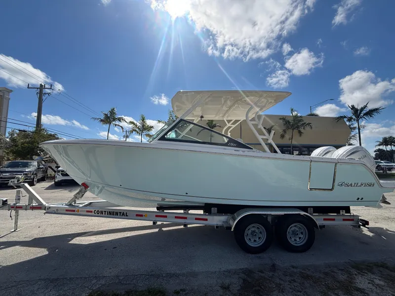 Slide: The Image of 2025 Sailfish 276 DC boat on trailer under sunny sky with palm trees. - 4