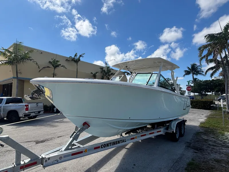 Slide: The Image of 2025 Sailfish 276 DC boat on trailer under clear blue sky. - 5