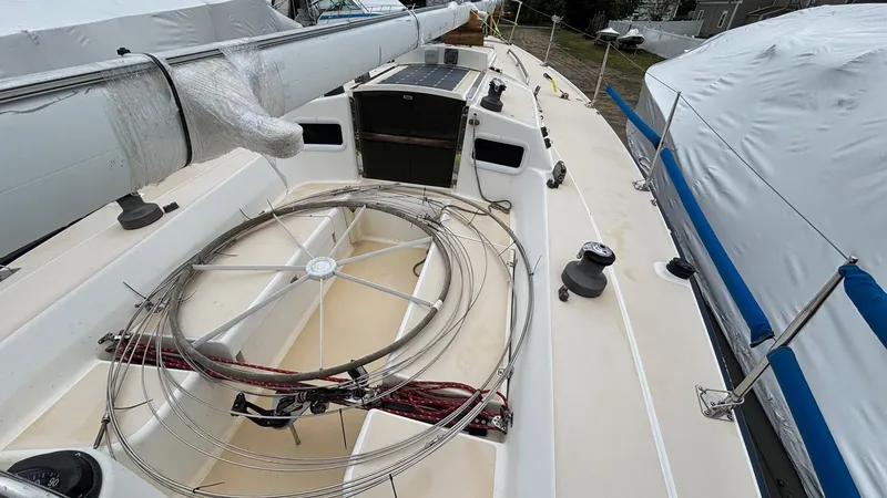 Slide: The Image of 2000 J Boats J/105 sailboat deck with coiled ropes and covered mast. - 26
