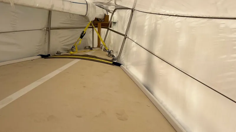 Slide: The Image of Interior view of a 2000 J Boats J/105 sailboat under a protective cover. - 7