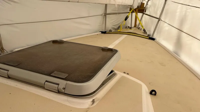 Slide: The Image of 2000 J Boats J/105 deck under cover, featuring a hatch and secured equipment. - 8