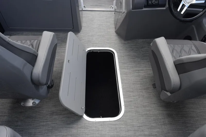 Slide: The Image of 2023 Bennington 25 RTFB boat interior with open storage compartment between seats. - 13
