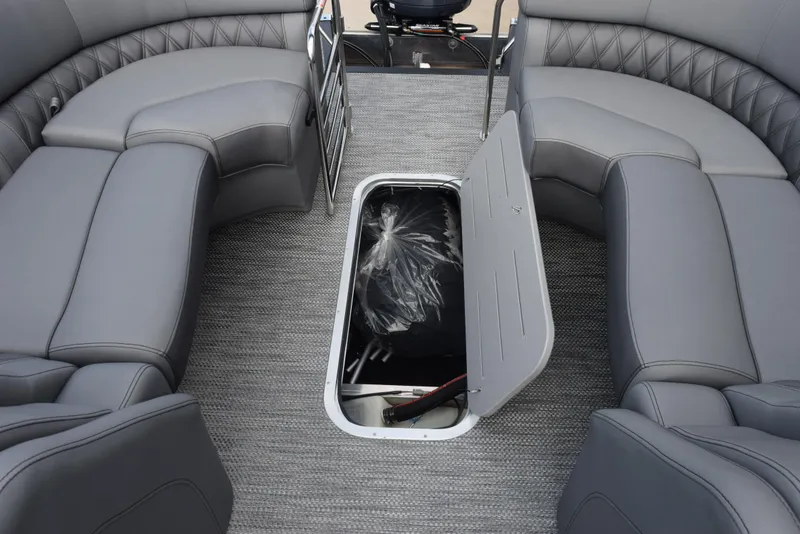 Slide: The Image of 2023 Bennington 25 RTFB boat interior with open storage compartment and gray seating. - 14