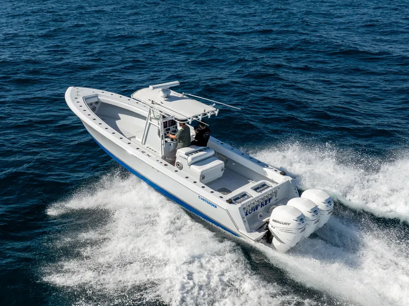 Slide: The Image of 2006 Contender 33 Tournament boat cruising on open water, featuring triple outboard engines. - 21