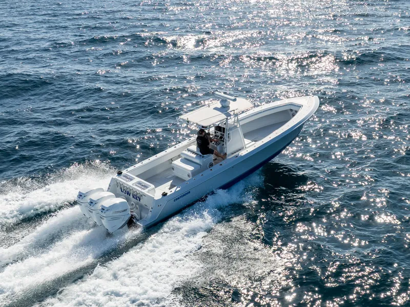 Slide: The Image of 2006 Contender 33 Tournament boat cruising on sparkling ocean waters. - 23