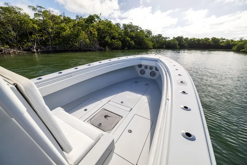 Slide: The Image of 2006 Contender 33 Tournament boat on calm water near lush green shoreline. - 27