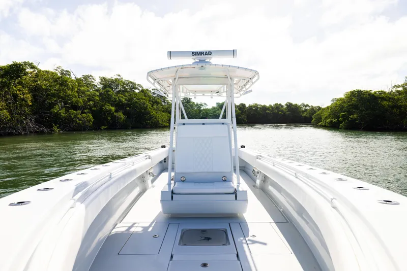 Slide: The Image of 2006 Contender 33 Tournament boat on calm water, surrounded by lush greenery. - 32
