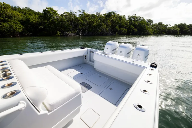 Slide: The Image of 2006 Contender 33 Tournament boat on calm water, featuring spacious deck and triple engines. - 36