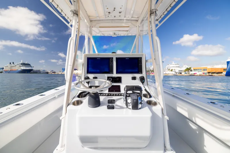 Slide: The Image of 2006 Contender 33 Tournament boat console with dual screens, steering wheel, and ocean backdrop. - 42