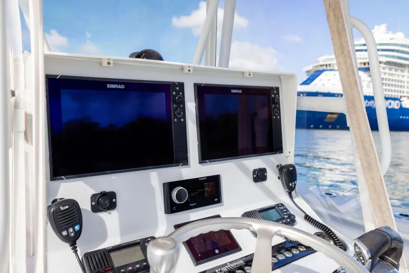 Slide: The Image of 2006 Contender 33 Tournament boat dashboard with navigation screens, microphones, and cruise ship in background. - 44