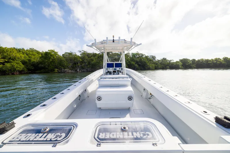 Slide: The Image of 2006 Contender 33 Tournament boat on calm water, surrounded by lush greenery. - 46