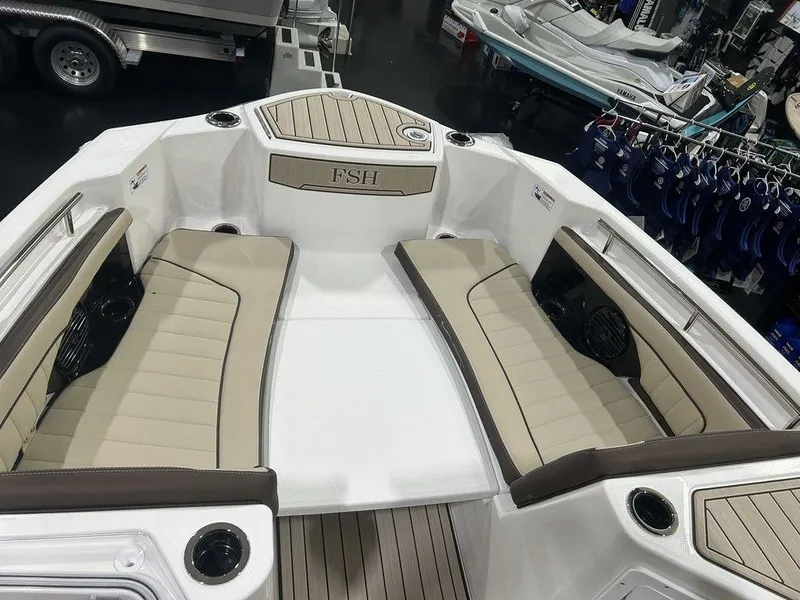 Slide: The Image of 2025 Yamaha Boats 255 FSH Sport H interior with beige seating and cup holders. - 2