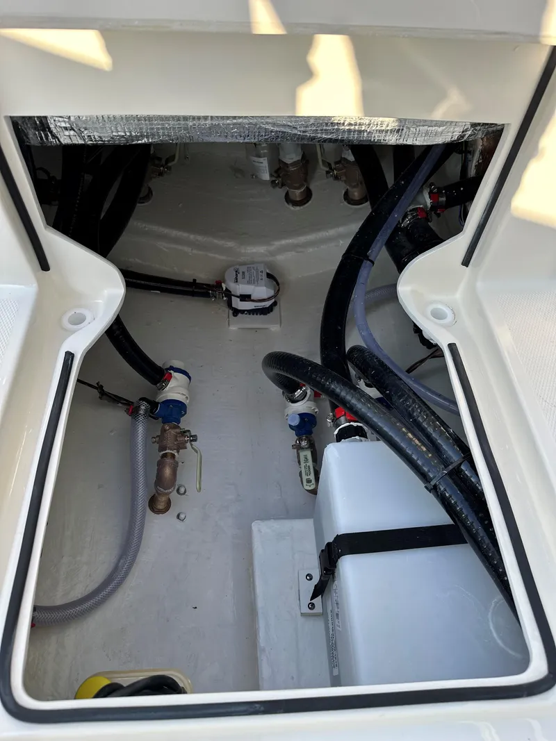 Slide: The Image of 2025 Pathfinder 2400 Open boat interior compartment with hoses and fittings. - 13